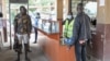 A port health officer screens travelers at a border post between Kenya and Uganda in Malaba, Kenya, on Aug. 20, 2024. Several African nations are screening for mpox amid an outbreak spreading around the continent.