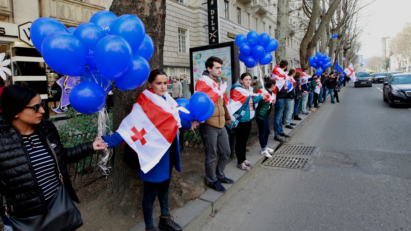 FILE - Supporters of the main opposition party wear Georgian national flags during a protest against buying gas from Russia's state-controlled Gazprom, in Tbilisi, Georgia, March 6, 2016. 