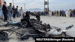 Afghanistan, Kabul, People stand at the site of a blast