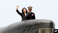 Taiwan's President Tsai Ing-wen, left, waves from a Zwaardvis-class submarine during a visit at Zuoying Naval base in Kaohsiung, southern Taiwan, March 21, 2017.