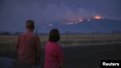 Warga menyaksikan dari jauh asap dan api kebakaran hutan di sebuah bukit dekat Kota Medford, Oregon, 9 September 2020. 