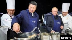 Presiden Rusia Vladimir Putin dan Presiden China Xi Jinping melakukan diplomasi "Pancake" dengan membuat kue pancake bersama-sama di sela acara Forum Ekonomi di Vladivostok, Rusia hari Selasa (11/9).