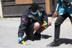 Members of the Haitian police and forensics look for evidence outside of the presidential residence in Port-au-Prince, Haiti, July 7, 2021.