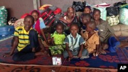 Yaman Ahmat, center, sits with her children at Bangui Airport after only hours earlier, her husband Marcus Madi, had put her and their eight children including newborn daughter Ashta onto a flight to the capital in a desperate bid to save their lives, but he was tragically killed on his return from the airport, March 7, 2014.