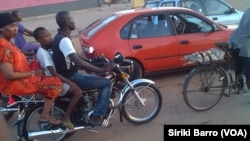 Un moto-taxi à côte d'un taxi à Bouaké, en Côte d'Ivoire, le 5 juin 2017. (VOA/Siriki Barro)