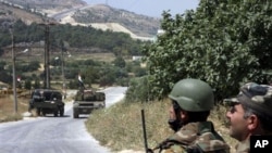 n this photo taken during a government-organized tour for the media, Syrian soldiers and armored vehicles arrive in Istabraq village near the northern town of Jisr al-Shughour, Syria, Saturday, June 11, 2011.