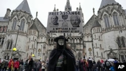 FILE - A protester stands outside the Royal Courts of Justice in London, Wednesday, February 21, 2024.