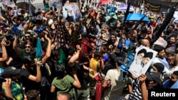 Supporters of Iraqi Shi'ite Muslim cleric Muqtada al-Sadr shout slogans during a protest over frequent electricity cuts after Friday prayers in Baghdad's Sadr City, Iraq, July 2, 2021.