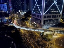 Pro-democracy protesters march into the night in Hong Kong, Dec. 8, 2019.