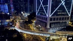 Pro-democracy protesters march into the night in Hong Kong, Sunday, Dec. 8, 2019.