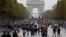 FILE - Pedestrians walk on the Champs Elysees avenue during the Car Free Day in Paris, Oct. 1, 2017. 