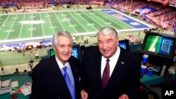 Pembawa acara asal stasiun televisi Fox Pat Summerall (kiri) dan John Madden berdiri di stan tempat mereka melangsungkan siaran NFL di salah satu stadion di New Orleans, pada 3 Februari 2002. (Foto: AP/Ric Field)