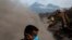 FILE - In this June 14, 2018, file photo, Mamerto Vazquez searches for his family killed by the eruption of the Volcano of Fire at his home buried in volcanic ash in San Miguel Los Lotes, Guatemala. 