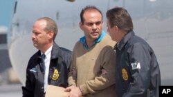 En esta fotografía de archivo del 13 de mayo de 2008, el caudillo paramilitar colombiano Salvatore Mancuso es escoltado por agentes de la DEA de Estados Unidos a su llegada a Opa-locka, Florida. 