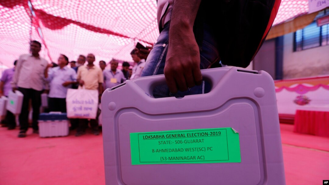 Para petugas Pemilu menjinjing tas berisi mesin untuk pemberian suara menjelang pelaksanaan pemilu di Ahmadabad, India, 22 April 2019. 