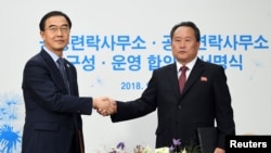 Ri Son-gwon, ketua Komite untuk Reunifikasi Damai Korea, berjabat tangan dengan Menteri Unifikasi Korea Selatan Cho Myoung-gyon setelah menandatangani dokumen pada upacara pembukaan kantor penghubung bersama di Kaesong, Korea Utara, 14 September 2018. (Foto: dok).