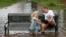 Katie Bender gets some assistance from Johanna Bender (L) as they dump water from a boot while sitting on a flooded street after Hurricane Arthur passed through in Manteo, N.C.