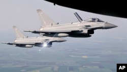 Архівне фото: Британські винищувачі Eurofighter Typhoon супроводжують транспортний літак над східною частиною Румунії у 2018 році. AP/Vadim Ghirda