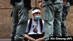 CHINA -- HONG KONG -- Riot police guard a protester as a second reading of a controversial national anthem law takes place in Central district, Hong Kong, Wednesday, May 27, 2020.