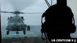 미 유도미사일 구축함 존 핀함(DDG 113)이 아라비아해에서 항해하며 미국의 대이란 봉쇄 조치를 이행하는 가운데, 한 미 해군 수병이 비행 작전을 감시하고 있다.