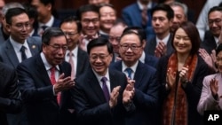 Hong Kong Chief Executive John Lee applauds with lawmakers following the passage of Article 23 at the Legislative Council in Hong Kong, March 19, 2024. Western governments criticized the national security law for its vagueness and potential repercussions for freedom of speech.