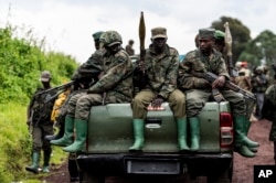 M23 rebels prepare to leave after a ceremony to mark the withdrawal from their positions in the town of Kibumba, in the eastern part of the Democratic Republic of Congo.