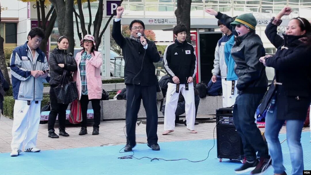Warga dan turis di Seoul, Korea Selatan, belajar gaya tarian lagu "Gangnam Style." (Foto: VOA)