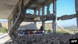 Yemeni pupils attend class on the first day of the new academic year, in a makeshift classroom in their school compound which was heavily damaged two years ago in an airstrike, in the country&#39;s third-city of Taez.
