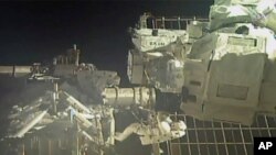 Commander Chris Cassidy, right, and NASA astronaut Bob Behnken perform their second spacewalk in under a week, July 1, 2020, to replace old batteries outside the International Space Station.