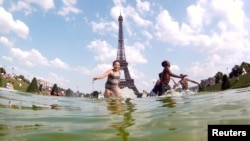 Anak-anak bermain air di air mancur Alun-Alun Trocadero di depan Menara Eiffel dalam sore musim panas yang terik di Paris (19/7). (Reuters/Gonzalo Fuentes)