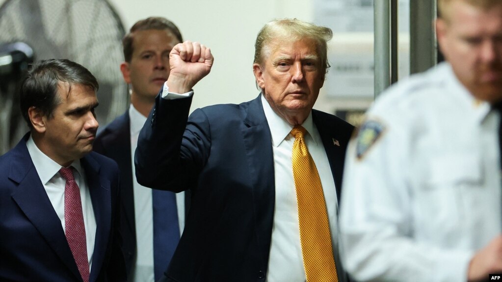 El expresidente estadounidense y candidato presidencial republicano Donald Trump levanta el puño cuando llega a su juicio penal en el Tribunal Penal de Manhattan en la ciudad de Nueva York, el 29 de mayo de 2024.