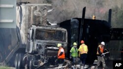 Petugas tampak membereskan puing-puing dari jalan tol di Lakewood, Colorado, pada 26 April 2019, setelah kecelakaan terjadi di area tersebut yang melibatkan truk pengangkut kayu. Sang supir truk Rogel Aguilera-Mederos divonis hukuman 110 tahun penjara. (Foto: AP/David Zalubowski)