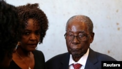 FILE - Zimbabwe's former President Robert Mugabe and his wife, Grace, vote in the general elections in Harare, Zimbabwe, July 30, 2018. 