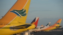 Pesawat Cebu Pacific (pertama, kiri), pesawat Philippines Airlines (kedua dari kiri) dan Cathay Pacific parkir di tarmac Bandara Internasional Manila, 2 November 2015. (Foto: Ted Aljibe/AFP Photo)