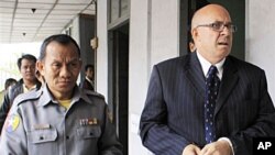 Ross Dunkley_founder and editor of the Myanmar Times_is escorted by a Myanmar policeman for a hearing at the Kamayut township court (file)