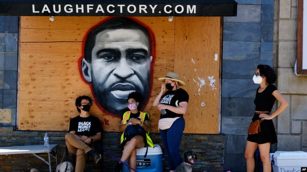 洛杉矶抗议者站在街边一副巨大的弗洛伊德壁画前面。(photo:VOA)