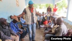 A UNICEF worker recruits participants for a community watch committee in Daro, a village in Guinea’s forest region. (Christophe Boulierac / UNICEF) 