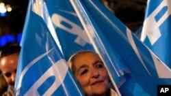 A supporter of Conservative Popular Party candidate Mariano Rajoy celebrates the results of the national election polls in Madrid, Spain, Sunday, Nov. 20, 2011.