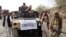 FILE - Armed militants of Tehrik-i-Taliban Pakistan (TTP) pose for photographs next to a captured armored vehicle in the Pakistan-Afghanistan border town of Landikotal, November 10, 2008.