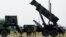 Dutch soldiers are seen standing next to a Patriot missile battery at a military base in Adana, southern Turkey, January 26, 2013.
