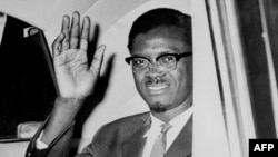 Patrice Lumumba salue depuis sa voiture à l'extérieur de l'aéroport d'Idlewild en route pour New York.