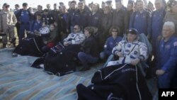 Le cosmonaute russe Anton Shkaplerov, l'astronaute américain Scott Tingle et l'astronaute japonais Norishige Kanai sont assis sur des chaises peu après le débarquement de la capsule spatiale russe Soyouz MS-07 à environ 150 km au sud-est de la ville kazak