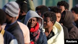 Des migrants d'Ethiopie et d'Erythrée font la queue lors d'une distribution de nourriture près de l'ancienne "jungle" à Calais, en France, le 23 août 2017.