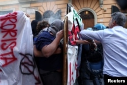 Protesters stand during a clash as they demonstrate against Italian Prime Minister Giorgia Meloni's government and its policies on the Gaza war, in Rome on June 1, 2024.