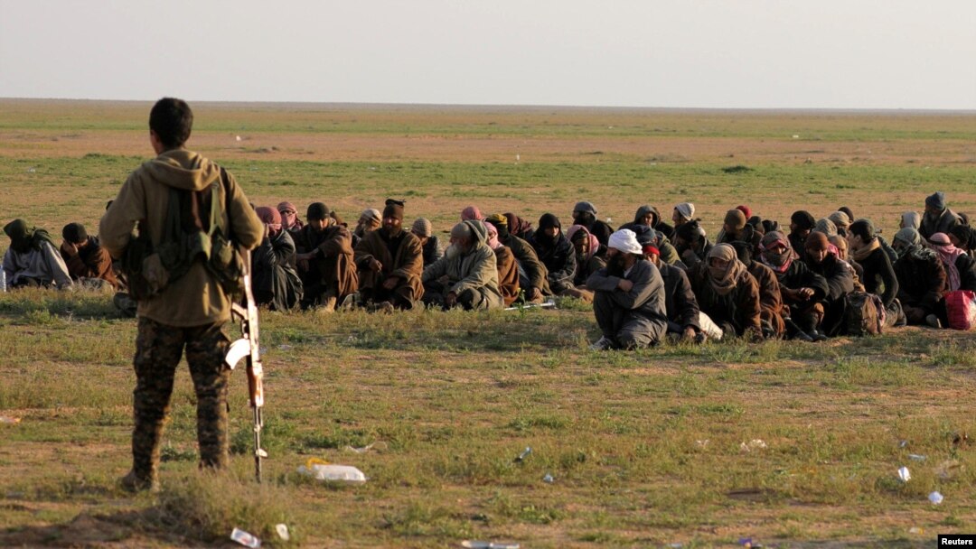 Seorang tentara Pasukan Demoktratik Suriah (SDF) yang didukung AS, berjaga dekat warga sipil dekat Desa Baghouz, Provinsi Deir Al Zor, Suriah, 22 Februari 2019. 