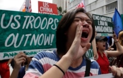 FILE - Protesters shout slogans as they march near the U.S. Embassy in Manila, Philippines, marking Independence Day, June 12, 2019. Among the demonstrators' demands was an end to the Visiting Forces Agreement with the United States.