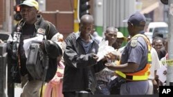 FILE: Zimbabweans pass a police cordon to submit their application forms outside the Immigration offices in Johannesburg, in a last minute bid to have their status in South Africa legalized (File Photo)