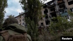 一名乌克兰警察走过阿瓦迪夫卡市一座被俄罗斯军队炸毁的居民楼。（2023年10月17日）