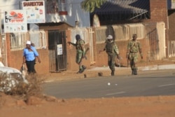 FILE - Soldiers patrol the streets in Harare, Zimbabwe, following demonstrations by opposition party supporters, Aug. 1, 2018.