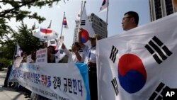 23일 한국 정부 서울청사 앞에서 시민단체들이 이산가족 상봉 연기를 통보한 북한을 규탄하고 있다.